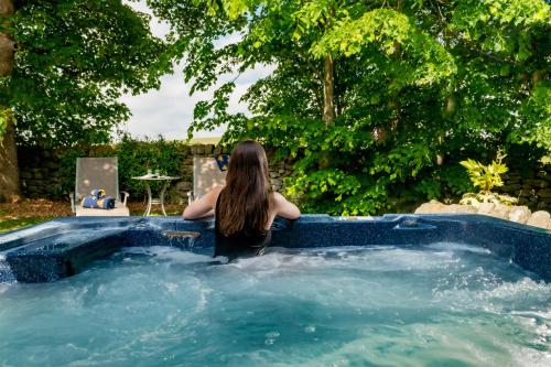a woman sitting in a jacuzzi in a pool at Dannah Farm Country House in Shottle