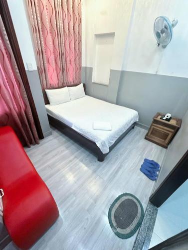 a small bedroom with a bed and a red curtain at Nhà Nghỉ Minh Châu in Hiệp Hòa