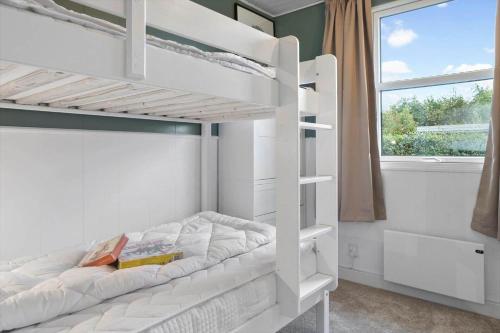 a white bunk bed in a room with a window at 40575-Juelsminde-Pot-Strandby-100 in Sønderby