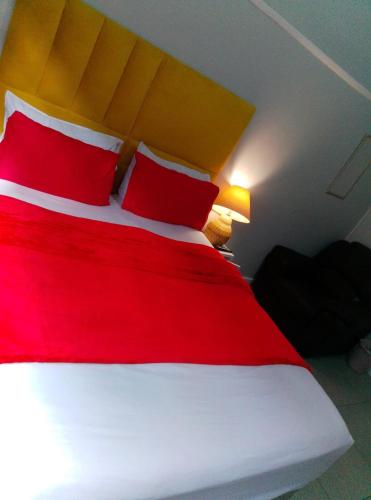 a red and white bed with red pillows in a room at Neo & Ruks rooms parow 2 in Avondale