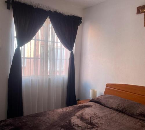 Un dormitorio con una cama y una ventana con cortinas. en Gran casa de descanso, en Tezoyuca