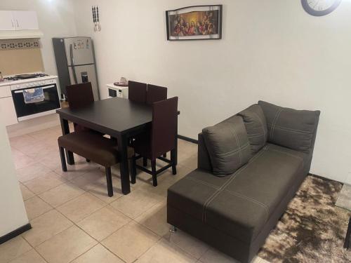 una sala de estar con una mesa y un sofá en Gran casa de descanso, en Tezoyuca
