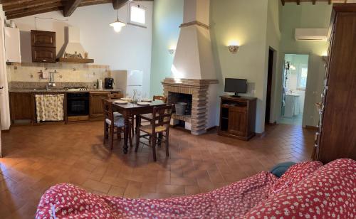 a living room with a table and a fireplace at La Collina dei Ciliegi in Brufa