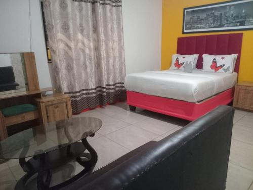 a bedroom with a bed and a glass table at Neo & Ruks rooms parow 2 in Avondale