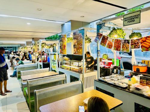 a fast food restaurant with people sitting at tables at Shore Bliss Staycation MOA in Manila