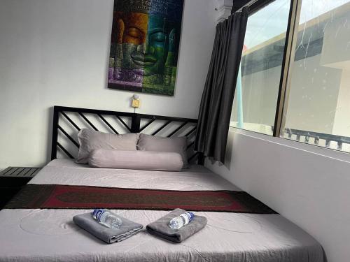 a bedroom with a bed with two slippers on it at The Eighty8 PP in Phnom Penh