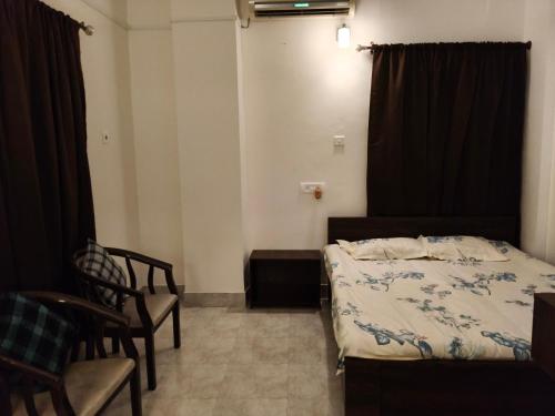 a small room with a bed and chairs in it at Mimo's in Guwahati
