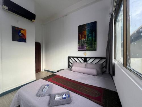 a bedroom with a bed in a room with a window at The Eighty8 PP in Phnom Penh