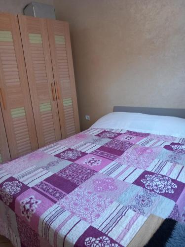 a bedroom with a bed with a quilt on it at Appartement séjour -Salam- éco Agadir in Agadir
