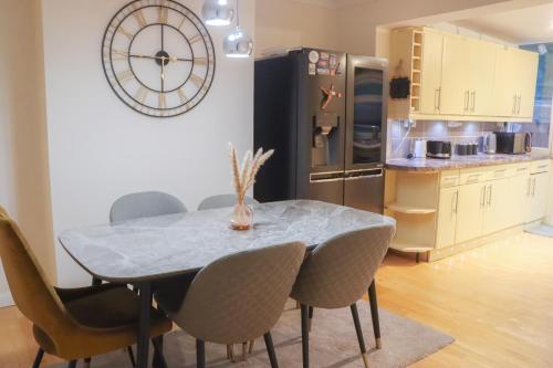 a kitchen with a table with chairs and a refrigerator at Beautiful 2 Bedroom house with big Garden & Parking fast wifi, and king size bed in Birmingham