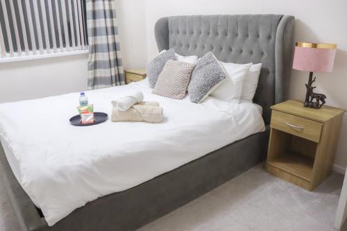 a bedroom with a large bed with white sheets and pillows at Beautiful 2 Bedroom house with big Garden & Parking fast wifi, and king size bed in Birmingham