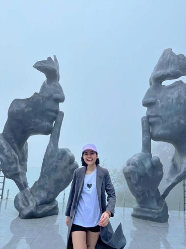 a woman standing in front of a statue at Nhà Nghỉ Sukha in Ba Vì