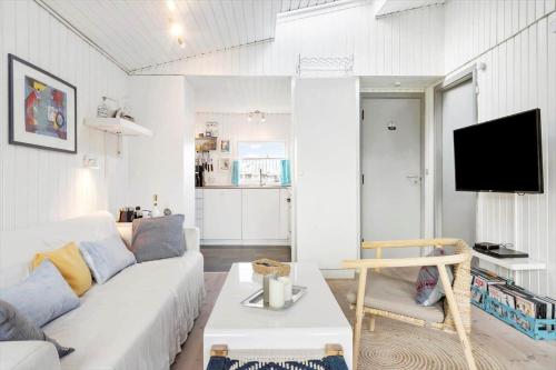 a living room with a white couch and a tv at 40388-Juelsminde-Frede-Juels-Vej-244 in Sønderby
