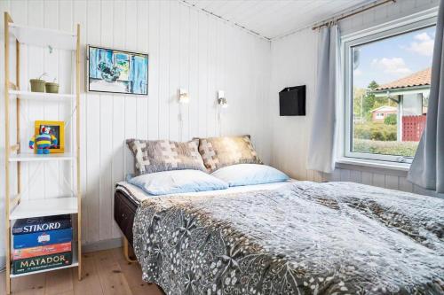 a bedroom with a bed and a window at 40388-Juelsminde-Frede-Juels-Vej-244 in Sønderby