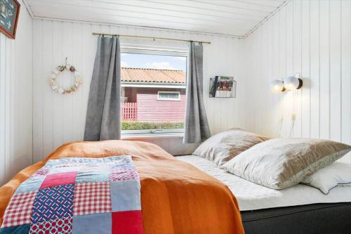a bedroom with a bed with a quilt on it at 40388-Juelsminde-Frede-Juels-Vej-244 in Sønderby