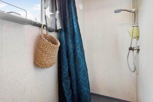 a shower curtain in a bathroom with a basket at 40388-Juelsminde-Frede-Juels-Vej-244 in Sønderby