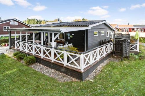 a black and white house with a porch at 40388-Juelsminde-Frede-Juels-Vej-244 in Sønderby