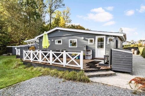 a tiny house with a fence in the yard at 40388-Juelsminde-Frede-Juels-Vej-244 in Sønderby
