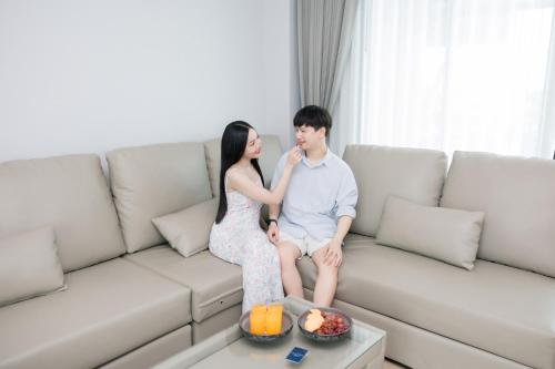 a woman sitting on a couch next to a man at The Horizon Groove Hotel in Ban Khlong