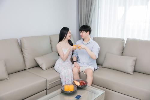 a man and woman sitting on a couch drinking coffee at The Horizon Groove Hotel in Ban Khlong