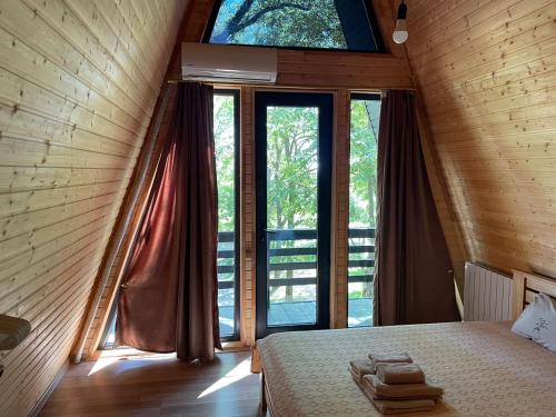 a bedroom with a bed and a large window at Gurgeniani Twin Cottages in Lagodekhi