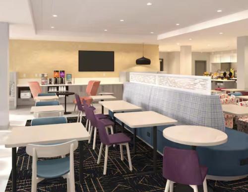 a restaurant with tables and chairs and a tv at Home2 Suites By Hilton St. Charles St.Louis in St. Charles