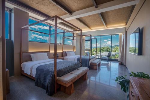 um quarto com duas camas e uma varanda em Zhangjiajie YOLO RELIAN Mt and River Collection-Riverside hotel with sunrise,sunset views, ticket service for attractions, afternoon tea,coffee, and laundry service em Zhangjiajie