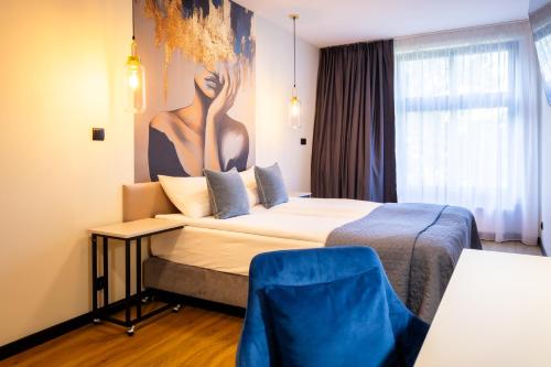 a hotel room with a bed and a painting on the wall at MOTTO Hotel Gdańsk Riverside OLD TOWN in Gdańsk