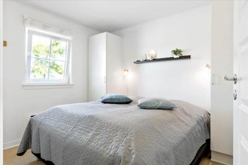 a white bedroom with a bed with two pillows at FY201-Brenderup-Fyn-Strandgardsvej-223 in Bro