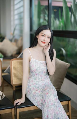a woman in a dress sitting on a chair at The Horizon Groove Hotel in Ban Khlong