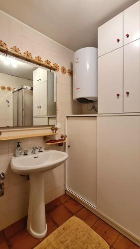 a bathroom with a sink and white cabinets at Nevi Apartment in Folgarida