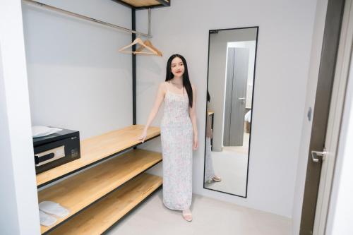 a woman is standing in a dressing room at The Horizon Groove Hotel in Ban Khlong