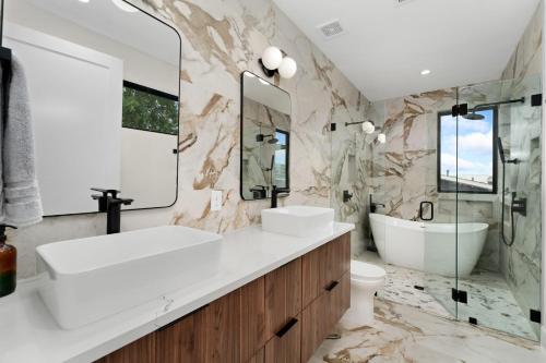 a bathroom with a sink and a tub and a toilet at Luxe Riverside Condo in Austin