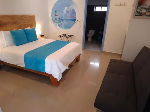 a bedroom with a large bed with blue pillows at Hotel IBIZA Beach Boutique in Jacó