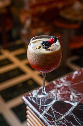 a drink with berries in a glass on a table at Marly Boutique Hôtel in Casablanca