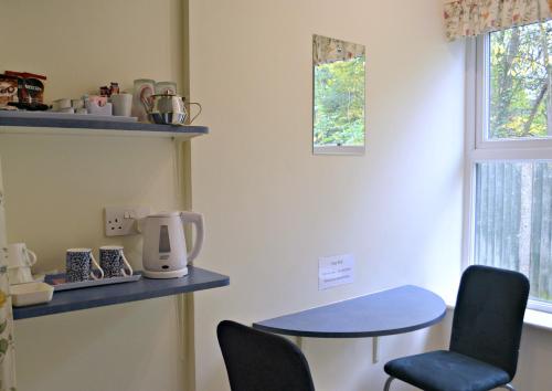 a room with a table and chairs and a window at Little Bullocks Farm in Takeley
