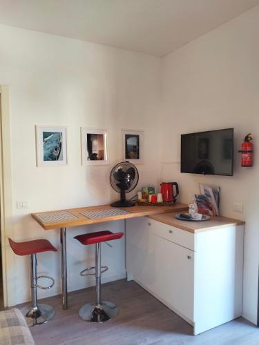 a kitchen with a desk with two stools and a tv at Chez Nous in La Spezia