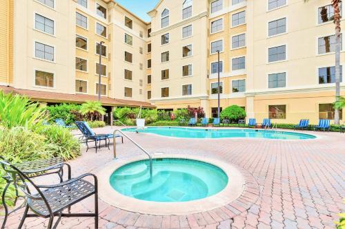 a hot tub in a courtyard with chairs and a building at King Suite near to Disney & Universal Fun in Orlando