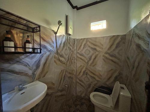 un baño con lavabo e inodoro en Frankies Island Home, en General Luna