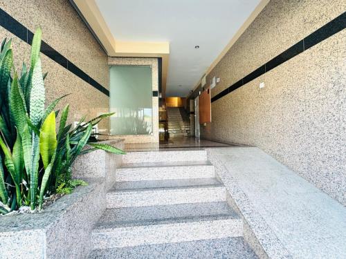 a hallway with stairs and plants in a building at NCHouse in Esposende