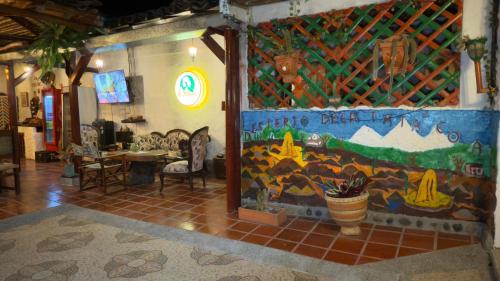 a room with a wall with a painting on it at La Liliana Hostal - Gastrobar in Jagua