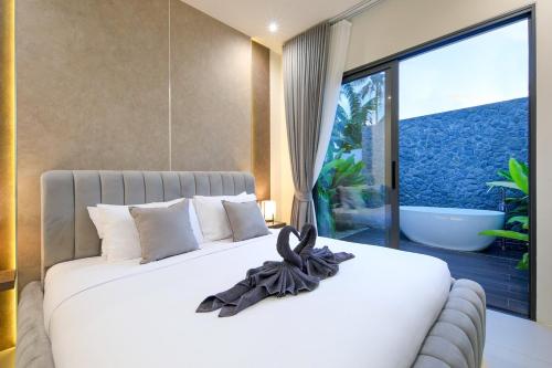 a bedroom with a white bed with a large window at Luxury Modern Villa Phuket - Thala in Phuket