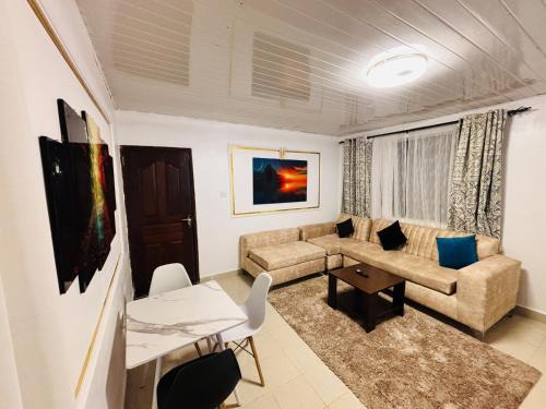 a living room with a couch and a table at Charme Home in Nanyuki
