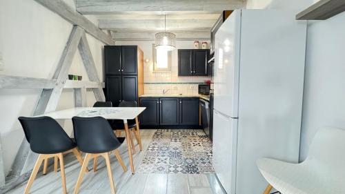 a kitchen with a table and chairs and a refrigerator at Relais du Dompeter in Molsheim
