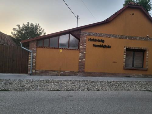 a building with a sign on the side of it at Holdvirág Vendégház in Jánoshalma