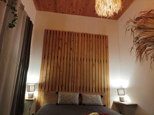 a bedroom with a large wooden headboard and a bed at Fleurs de Lys in Friville-Escarbotin