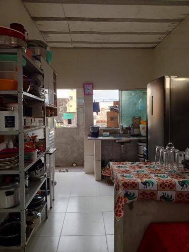 a kitchen with a table and a refrigerator at cantinho da Raq,um quarto SUÍTE com ar condicionado duas camas de casal perto doAeroporto, UEPA, Rodoviaria, magueirao, UFPA,parque ambiental, in Belém