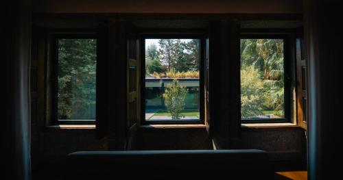 a room with three windows and a blue couch at Quinta de Silvalde in Santo Tirso