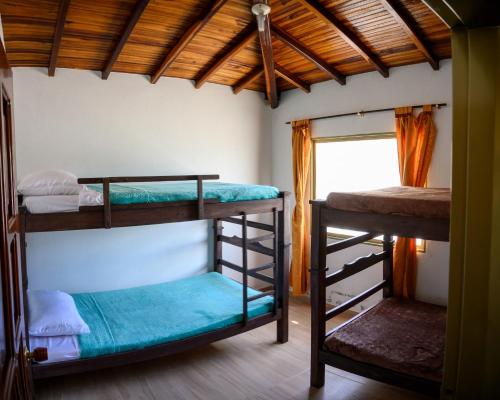 a room with three bunk beds and a window at Finca Guacari (San Gil) in San Gil