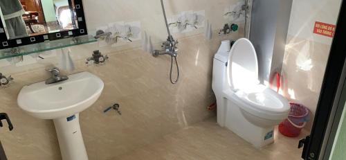 a bathroom with a toilet and a sink at Quỳnh Chi Hotel in Pan Linh